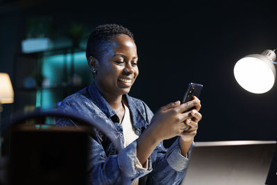 Young man using mobile phone while sitting at home