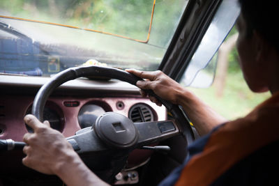 Rear view of a cropped man driving car