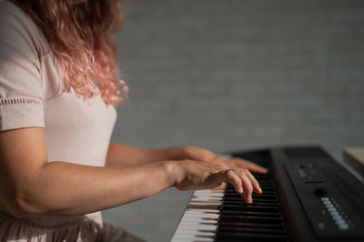 Midsection of woman playing piano