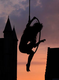 Low angle view of silhouette woman against sky during sunset