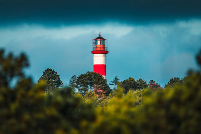 Lighthouse by sea against sky