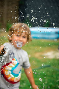 Full length of cute boy playing in water