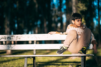 Portrait of pre teenager boy sitting on a bench