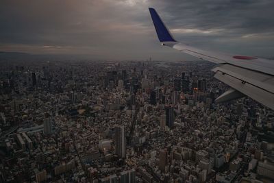 Cropped image of airplane flying over cityscape
