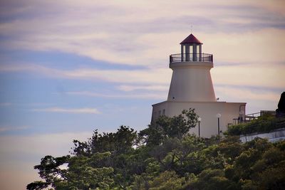 Lighthouse by sea against sky