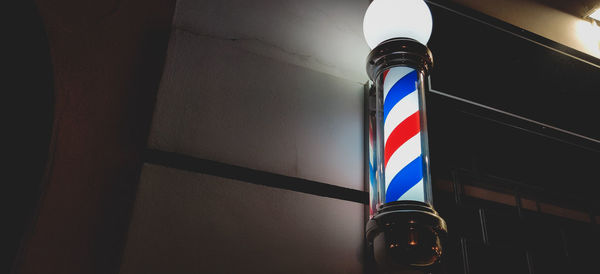 Low angle view of illuminated sign on wall