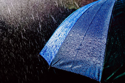 High angle view of raindrops on blue umbrella during monsoon