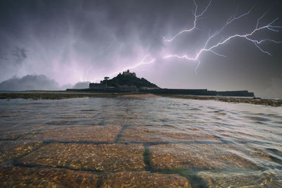 Lightning over sea against storm clouds