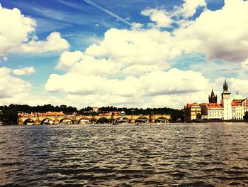 Scenic view of river by city against sky