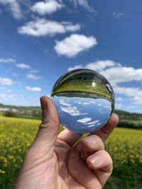 Midsection of person holding crystal ball on field