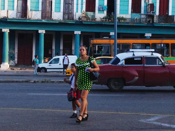 Full length of friends standing on street in city