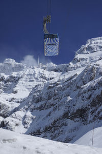 Overhead cable car on snowcapped mountains against sky