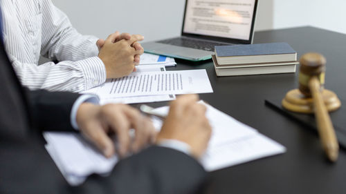 Midsection of business colleagues working on table