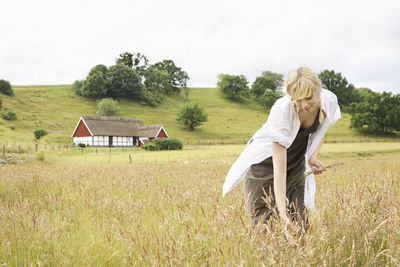 Woman picking grass on meadow