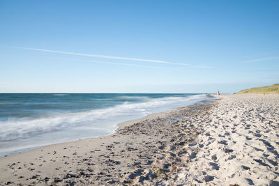 Scenic view of beach against clear blue sky