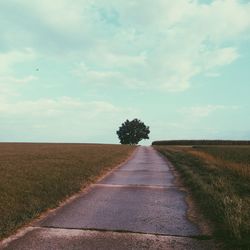 Scenic view of field against cloudy sky