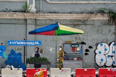 People standing against graffiti wall