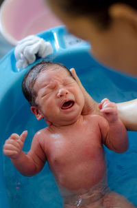 High angle view of shirtless baby boy in swimming pool