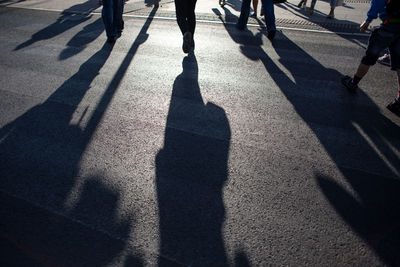 Shadow of people walking on road in city