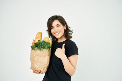 Portrait of smiling young woman against white background