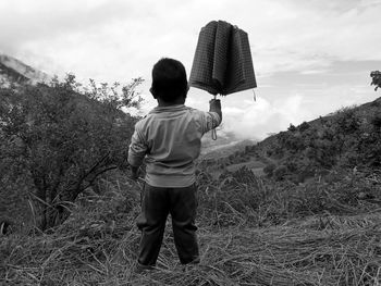 Rear view of boy standing on field