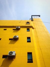 Low angle view of yellow building against sky