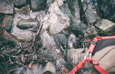 Man standing on rock against waterfall