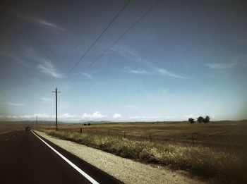 Empty road passing through field