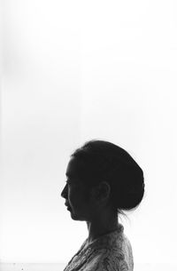 Side view of young woman against white background