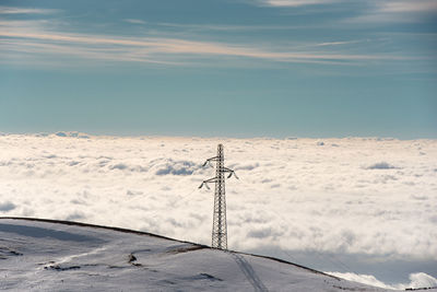 Low angle view of telephone pole against sky during winter