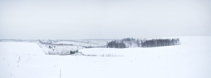 Scenic view of snowcapped field against sky