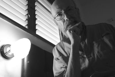 Side view of man looking through window