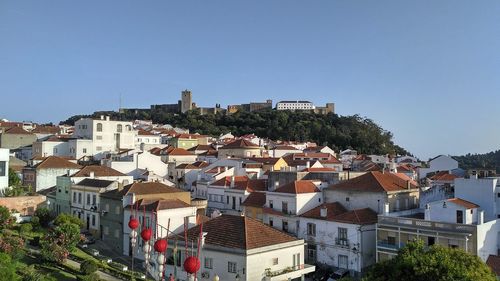 Houses in town against clear blue sky