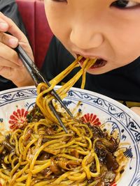 Midsection of woman eating noodles