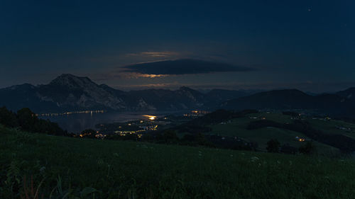 Scenic view of illuminated mountains against sky at night