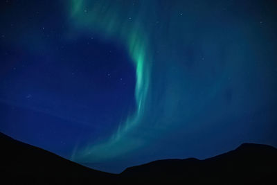 Low angle view of silhouette mountain against sky at night