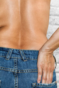 Midsection of shirtless woman wearing jeans