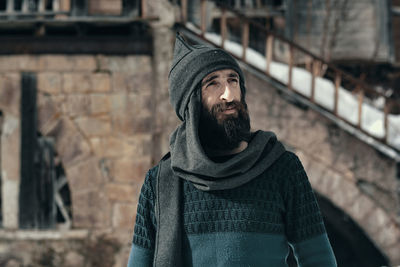 Mid adult man looking away while standing outdoors