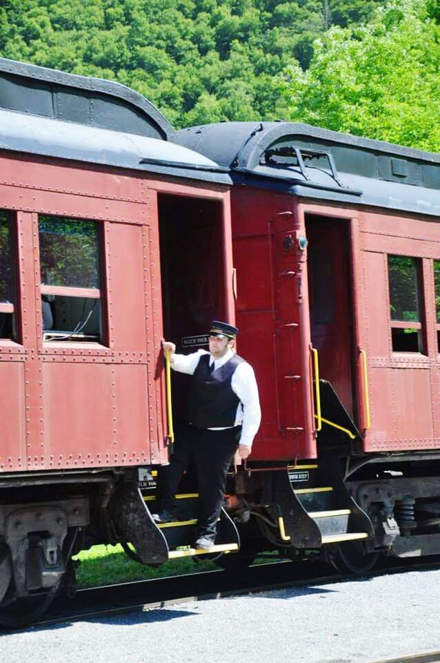 MAN STANDING ON RAILROAD STATION PLATFORM