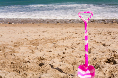 Close-up of pink water on beach against sky