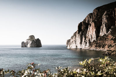 Scenic view of so called pan di zucchero rocks formation in sea against clear sky