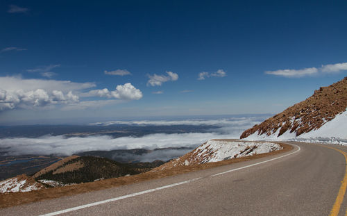 Scenic view of mountains against sky, road above the cluds