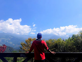 Rear view of man looking at mountain against sky