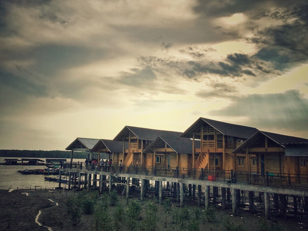 HOUSES ON BEACH AGAINST SKY DURING SUNSET