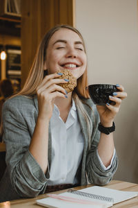 Smiling girl drinking coffee at cafe