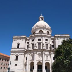 Low angle view of historical building against clear blue sky