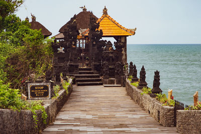 Exterior of temple building by sea against sky