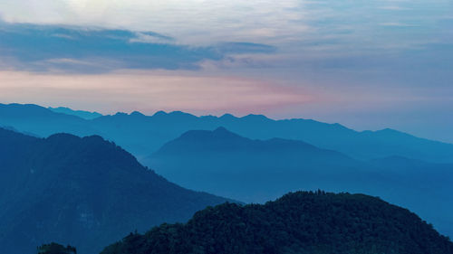 Scenic view of mountains against sky at dawn