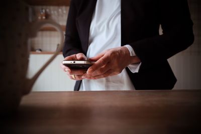 Close-up of man using laptop on table