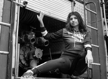 Portrait of a young woman sitting on truck